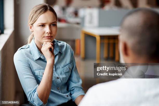 shot of a young businesswoman having a discussion with a colleague in a modern office - serious interview stock pictures, royalty-free photos & images