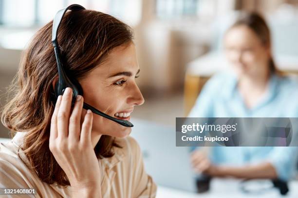 schuss einer jungen frau mit einem headset in einem modernen büro - callcenter stock-fotos und bilder