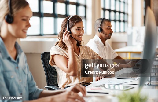 Shot of a young woman using a headset and computer in a modern office Shot of a young woman using a headset and computer in a modern office