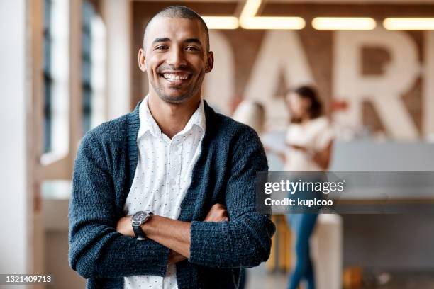 portret van een zekere jonge zakenman die in een modern bureau werkt - folded arms stockfoto's en -beelden