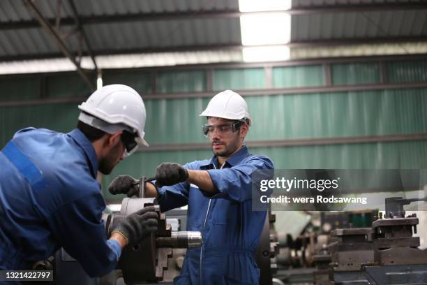 factory engineers examining and maintenance the industrial machinery - maschinenbau stock-fotos und bilder