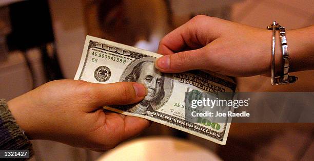 Shopper pays cash for sales merchandise December 26, 2000 at the Lakeline Mall in Austin, Texas. Stores were hoping that after Christmas shopping...