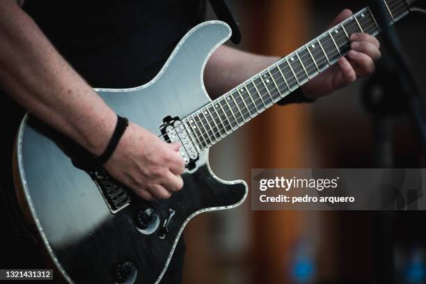 hands playing a chord on an electric guitar - guitar photos et images de collection