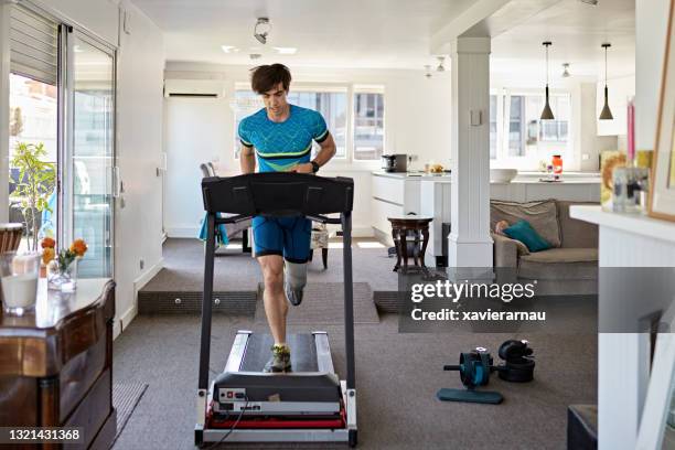 fit mid adult man working out at home on treadmill - treadmill stock pictures, royalty-free photos & images