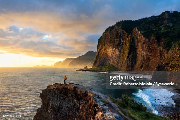 man admiring sunrise from cliffs, madeira - island imagens e fotografias de stock
