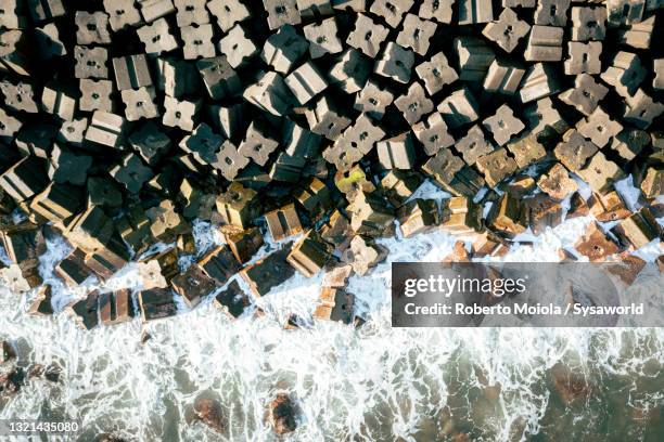 waves crashing on blocks of seawall, madeira - madeira material stock pictures, royalty-free photos & images