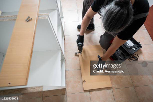 mature man disassemble old kitchen - disassembling stockfoto's en -beelden