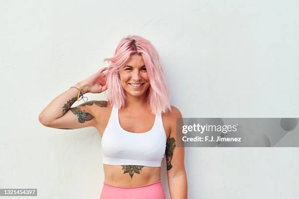 portrait of woman with pink hair in front of white wall - young women white background stock pictures, royalty-free photos & images