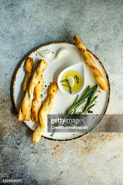 grissini breadsticks on a plate with olive oil, garlic and rosemary - olive oil bowl stock pictures, royalty-free photos & images