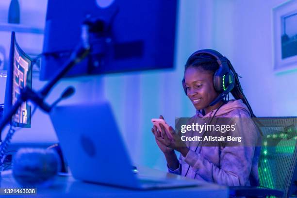 young female gamer looking at smartphone - broadcasting room stock pictures, royalty-free photos & images