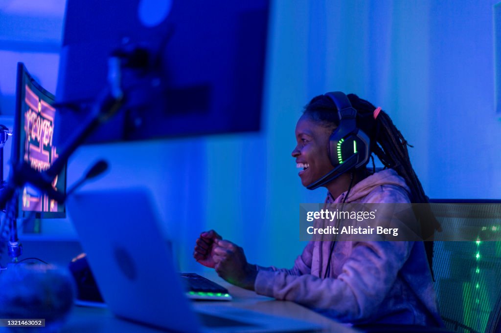 Young black female gamer celebrates at night