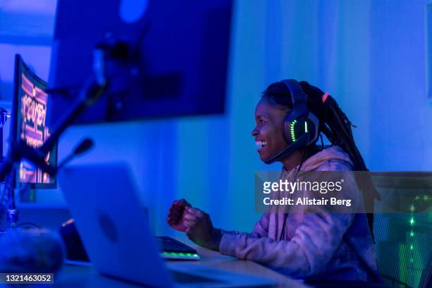 young black female gamer celebrates at night - arts culture and entertainment stock pictures, royalty-free photos & images