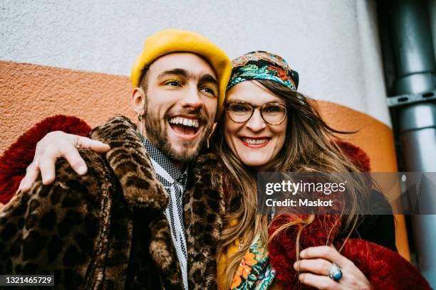 portrait of smiling mature woman with cheerful young man - yellow hat stock pictures, royalty-free photos & images