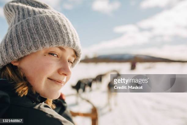 portrait of teenage girl wearing knit hat doing dogsledding during winter - schwedisch lappland stock-fotos und bilder