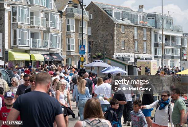 Large crowds of people gather around the harbour at the popular tourist seaside town of St Ives, close to The Carbis Bay Estate hotel and beach,...