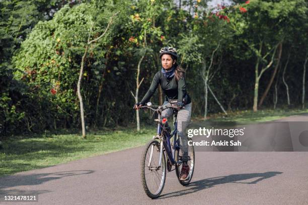 portrait of a fit indian female cyclist out of a training ride on her bicycle. - indian riding stock pictures, royalty-free photos & images