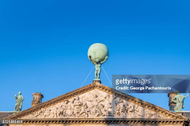 sculptures on the pediment of the royal palace in dam square, amsterdam - internationaal monument stockfoto's en -beelden