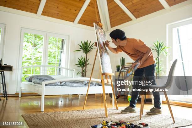 japanese man spending weekend morning painting in his bedroom at home - painter beret stock pictures, royalty-free photos & images