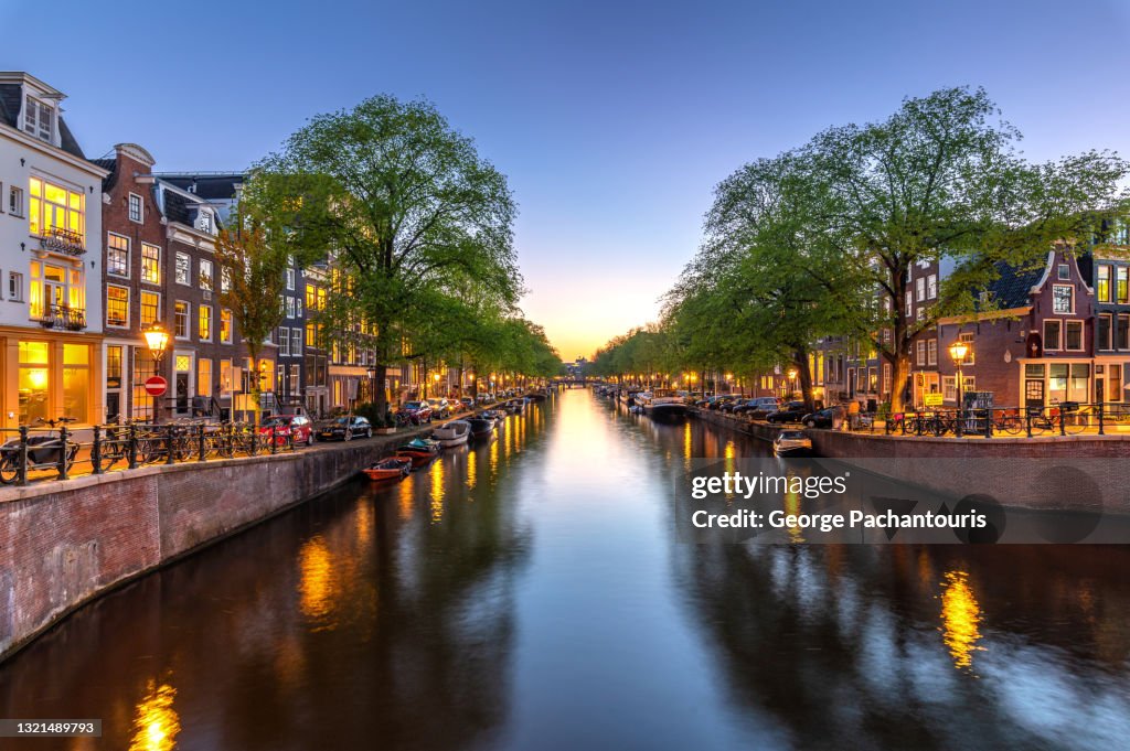 Beautiful canal in Amsterdam with city lights turned on