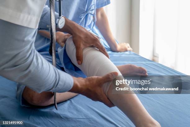 physical doctor consulting with patient knee problems physical therapy. - coluna vertebral humana imagens e fotografias de stock