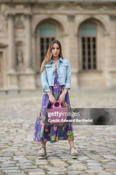 Maria Rosaria Rizzo @lacoquetteitalienne wears a blue faded denim ripped short jacket, a long puffy purple dress with orange pink and green flower...