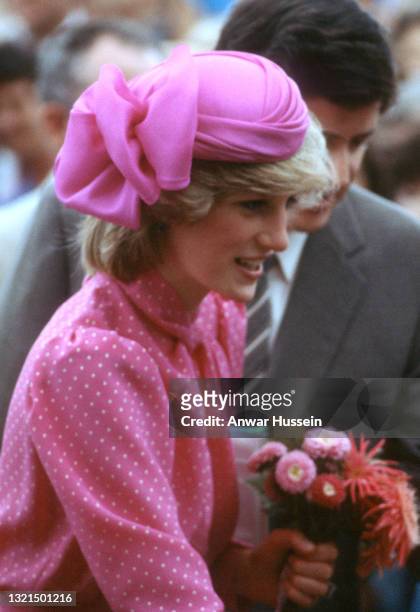Diana, Princess of Wales, wearing a pink and white polkadot dress designed by Donald Campbell and a pink hat designed by John Boyd, greets...