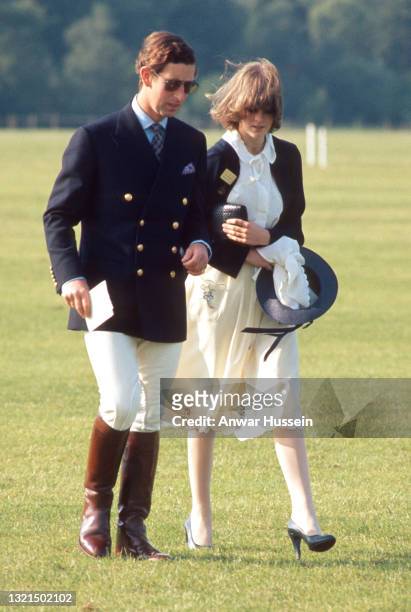 Prince Charles, Prince of Wales, wearing a navy blue blazer with jodhpurs, riding boots and aviator sunglasses, walks next to his girlfriend Lady...