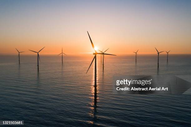 offshore wind turbines at sunrise seen from an aerial point of view, redcar, england, united kingdom - offshore windfarm stock-fotos und bilder