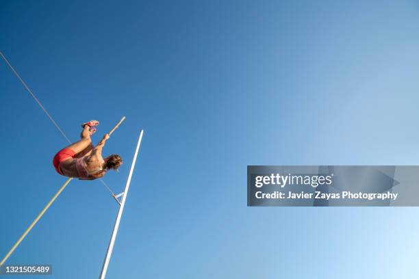 young woman pole-vaulting - pole vault stock pictures, royalty-free photos & images