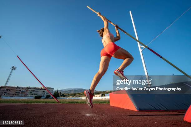 young woman pole-vaulting - pole vaulter stock pictures, royalty-free photos & images