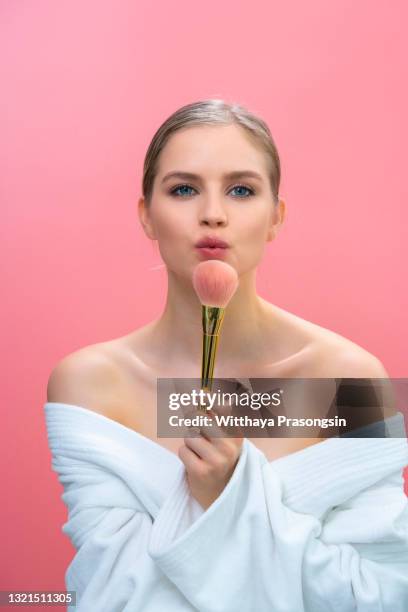 beautiful woman applying make-up - applying makeup with brush foto e immagini stock