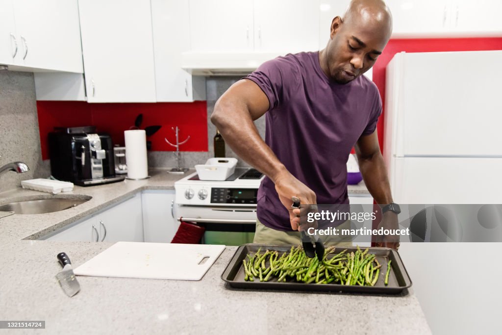 Reife afroamerikanische Mann Kochen Mahlzeit in seiner Küche.