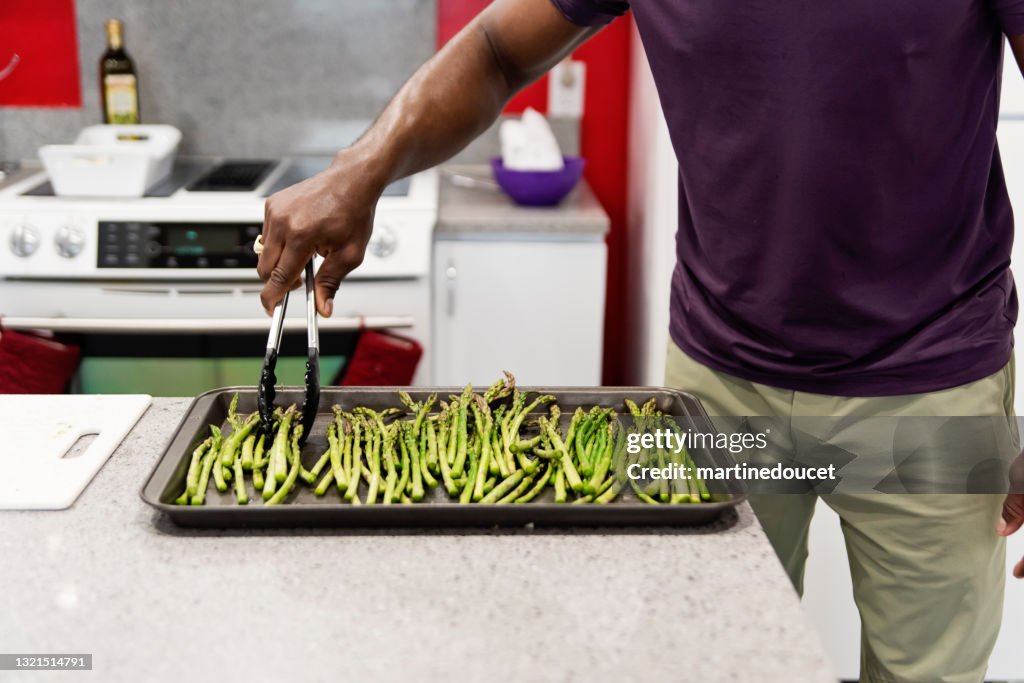 Maturo afro-americano cucina pasto nella sua cucina.