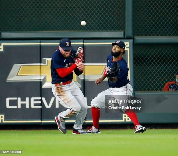 Danny Santana of the Boston Red Sox and Alex Verdugo avoid colliding with each other as Santana makes the catch in the first inning against the...