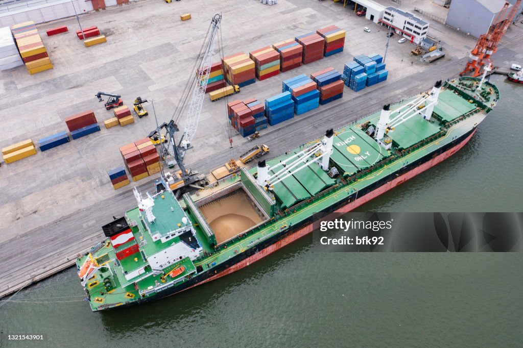 Aerial view of a large cargo ship loading grain.