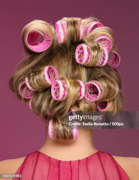 rear view of woman with curlers in hair,italy - hair curlers stockfoto's en -beelden