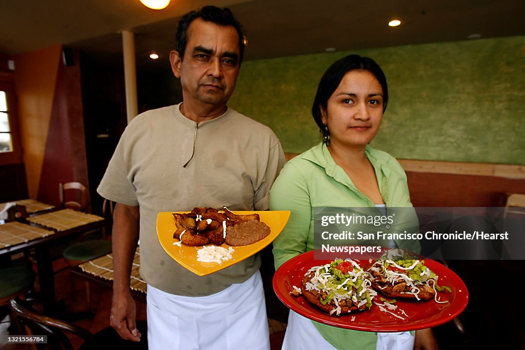 BARGAIN20_MAIZ_070_LH.JPG   Francisco Grande and his daughter/manager Isabelle Grande at Maiz, a Salvadorian restaurant in Berkeley.  He is holding platanos y frijoles fritos--honey sweet fried plantains served w/fried beans and salvadorian so