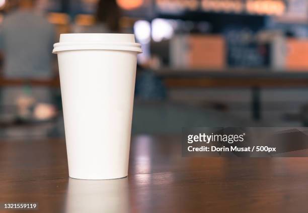 close-up of disposable cup on table - takeaway coffee cup stock-fotos und bilder