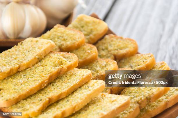 close-up of crispy garlic bread in plate on table - garlic bread stock pictures, royalty-free photos & images