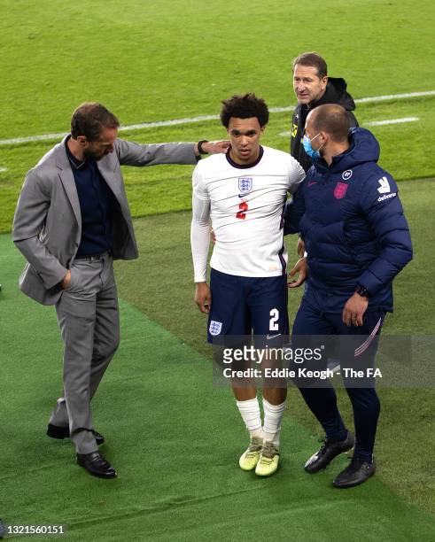 Gareth Southgate, Head coach of England pats Trent Alexander-Arnold of England on the back as he reacts after being substituted with a injury during...