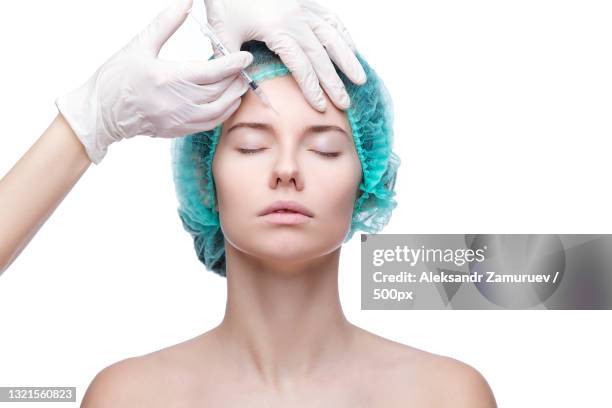 portrait of young caucasian woman getting cosmetic injection - blepharisma stockfoto's en -beelden