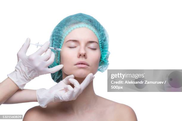 portrait of young caucasian woman getting cosmetic injection - blepharisma stockfoto's en -beelden