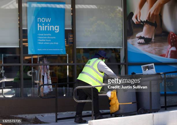 Worker pushes a cart by a Now Hiring sign outside of a Ross store on June 03, 2021 in Sausalito, California. According to a U.S. Labor Department...