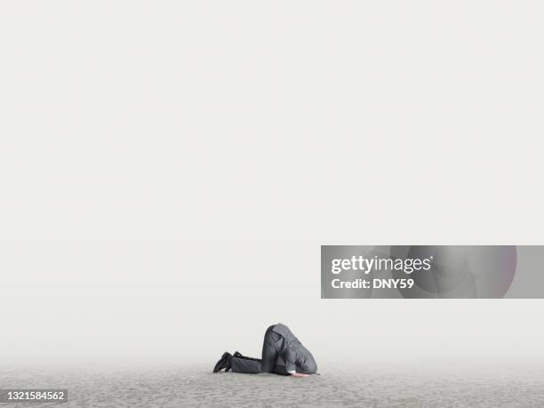 uomo con la testa sepolta nella sabbia - indifferenza foto e immagini stock