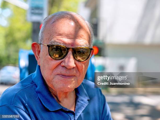 senior hispanic man looking at the camera wearing sunglasses - man sunglasses stock pictures, royalty-free photos & images