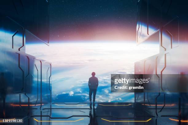 lässiger mann steht auf weltraumplattform und beobachtet planet erde - empty space stock-fotos und bilder