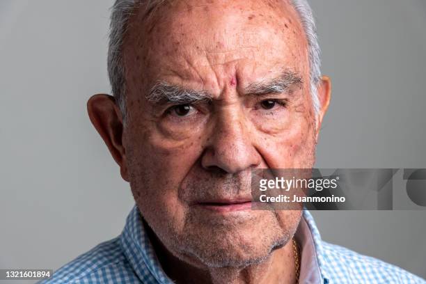 homme âgé hispanique sérieux mugshot avant - vieux grincheux photos et images de collection