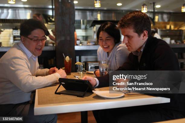 Sidney Chen , Cindy Matsuyama , and Ivan Tsurikov from Connective Capital Management, LLC, looking at a new tablet that restaurants can put at every...