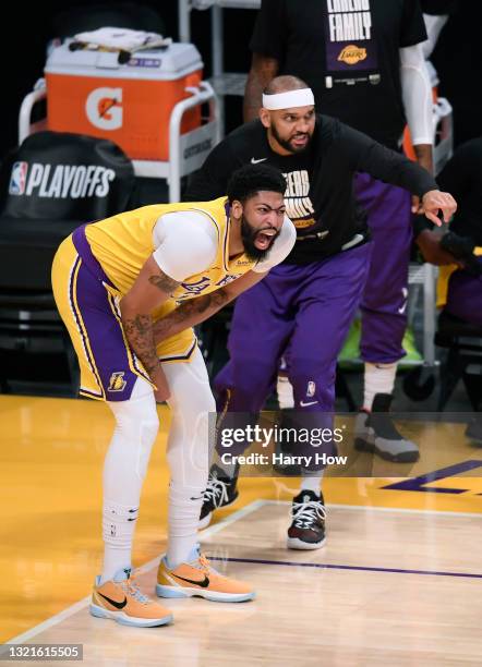 Anthony Davis of the Los Angeles Lakers grimaces next to Jared Dudley before leaving the game against the Phoenix Suns in the first quarter during...