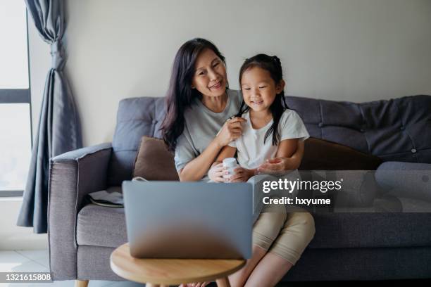 telemedicine asian family video calling doctor with a laptop - mentoring virtual stock pictures, royalty-free photos & images